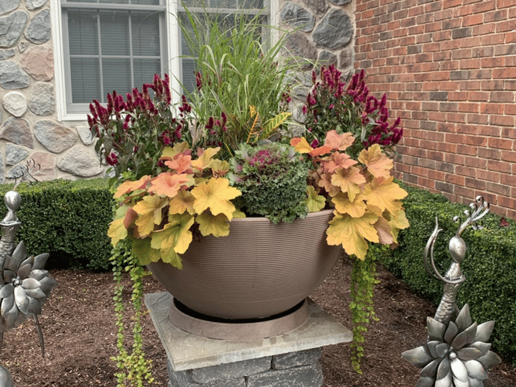 Matching saucer and planter with fall arrangement.