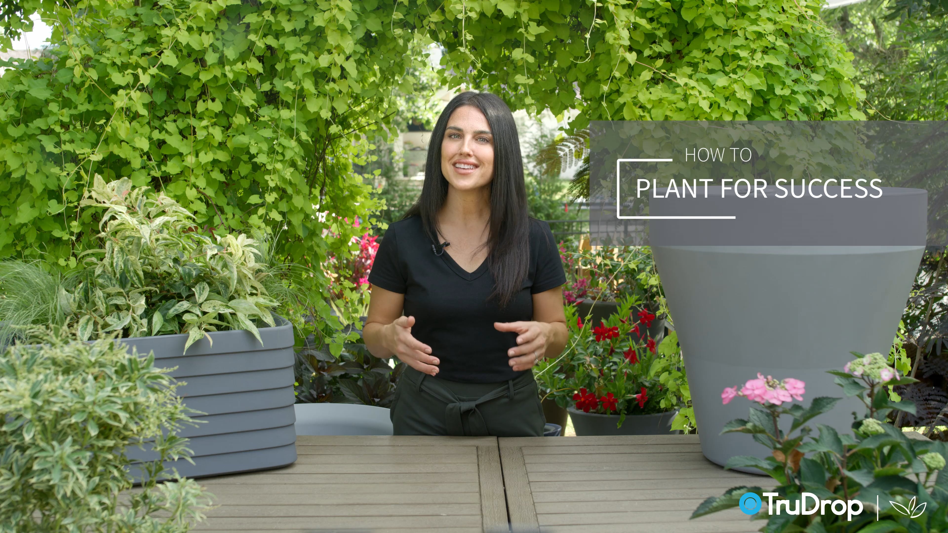 TruDrop how to plant for success video thumbnail with woman surrounded by planters and greenery